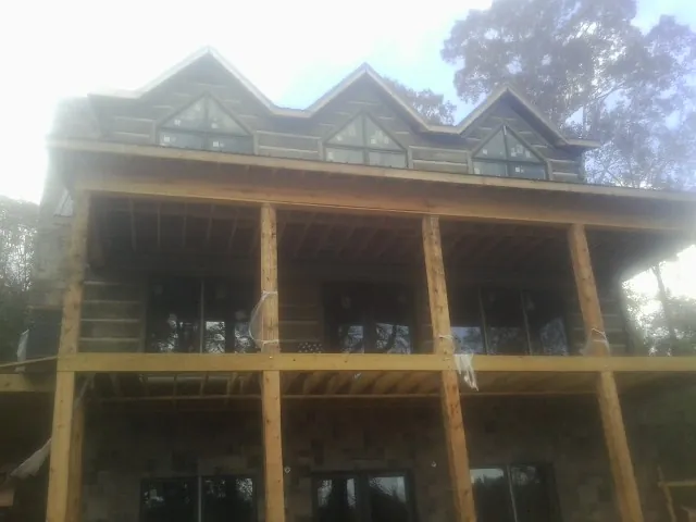 Dormers and porch framing on a large log home under construction — Roof Coating work by our crew in Carson