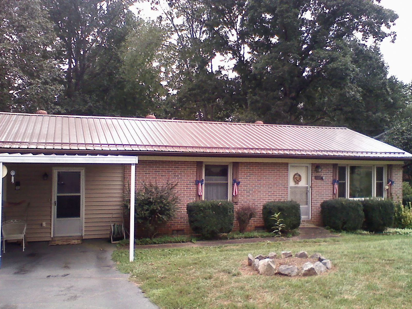Bronze metal roof and carport on a brick ranch home — Roof Repair work by our crew in Carson